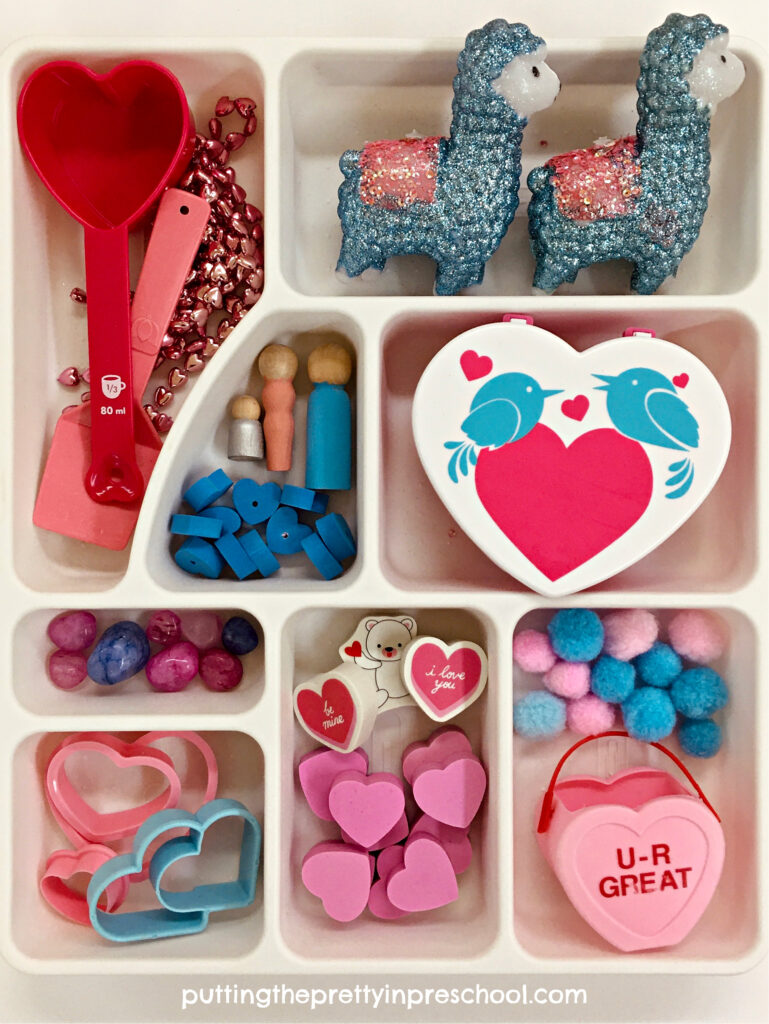 Loose parts for an adorable llama-inspired valentine sensory bin with a rice base.