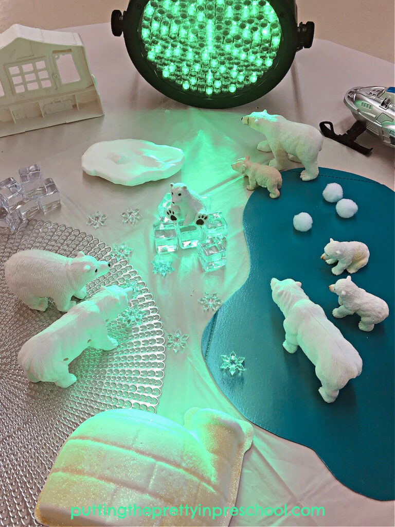 A professional stage light adds ambiance to this inviting northern lights-inspired polar bear small world.