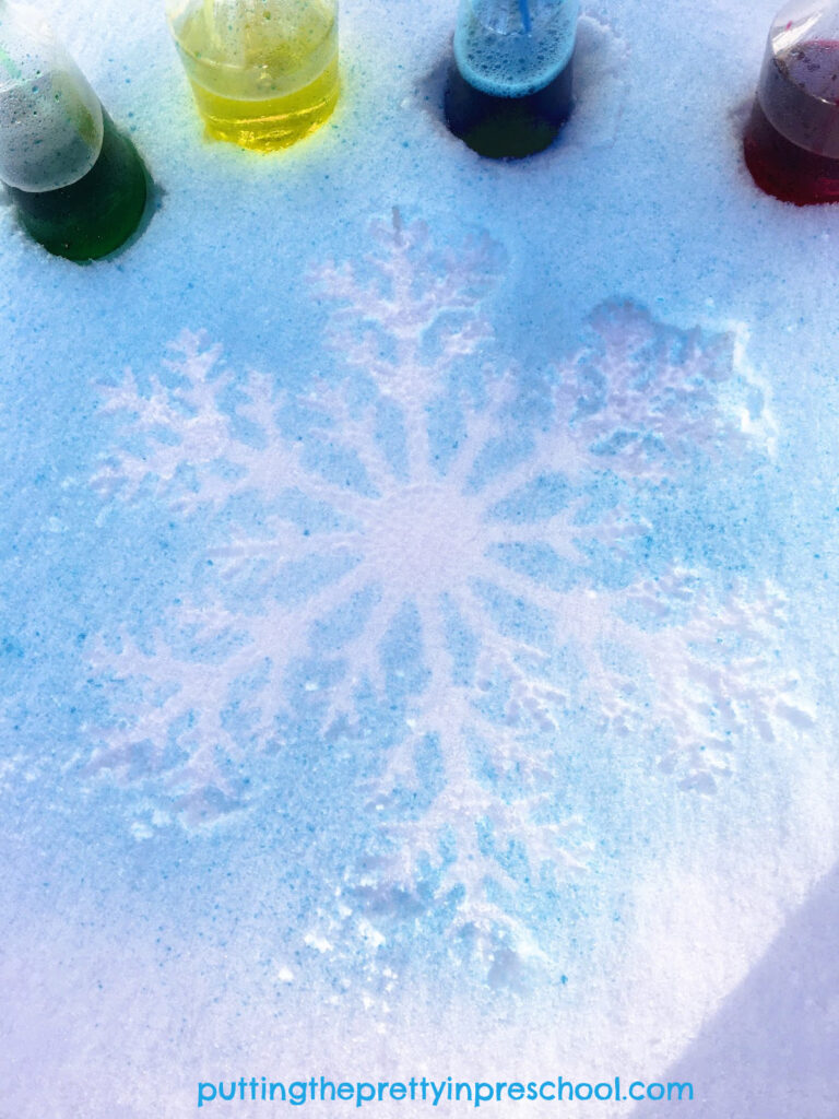 A beautiful blue background snowflake silhouette created with a spray paint technique. A quick and easy ourdoor transient art activity.