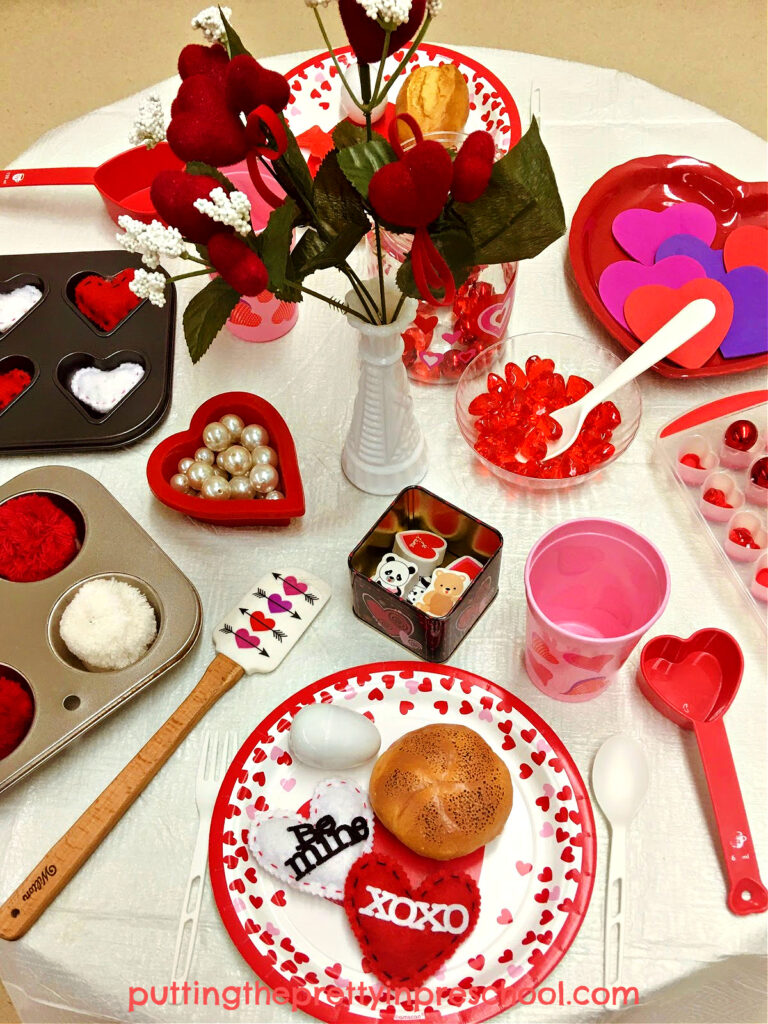 A super fun Valentine's Day pretend play tablescape with lots of heart-themed accessories.