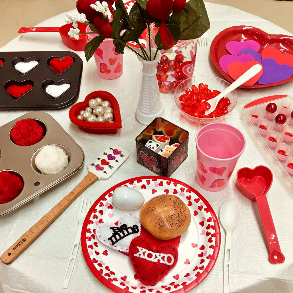 Lots of hearts and red and white loose parts make this Valentine's Day pretend play tablescape fun to play in.