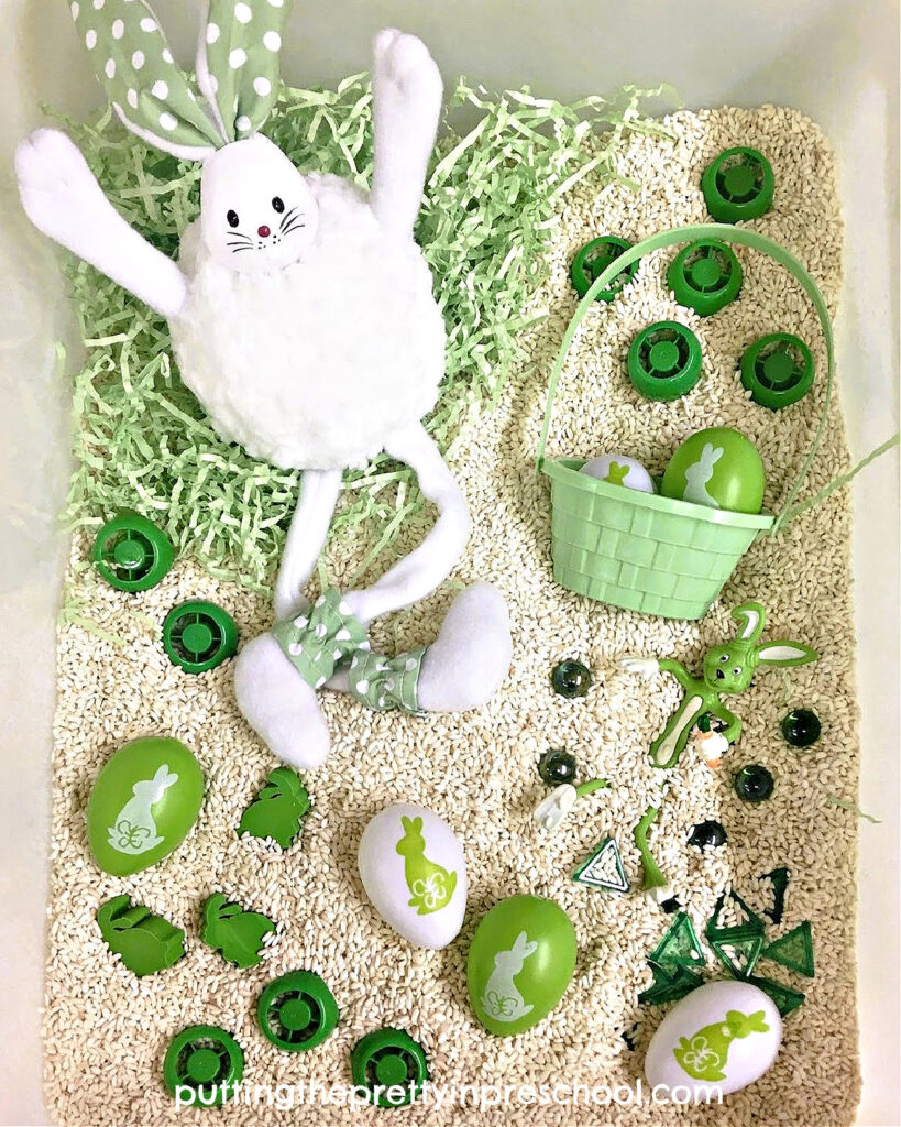 This green and white bunny-themed rice bin gives you all the feels. Loose parts coordinate with the bunnies and eggs in the bin.
