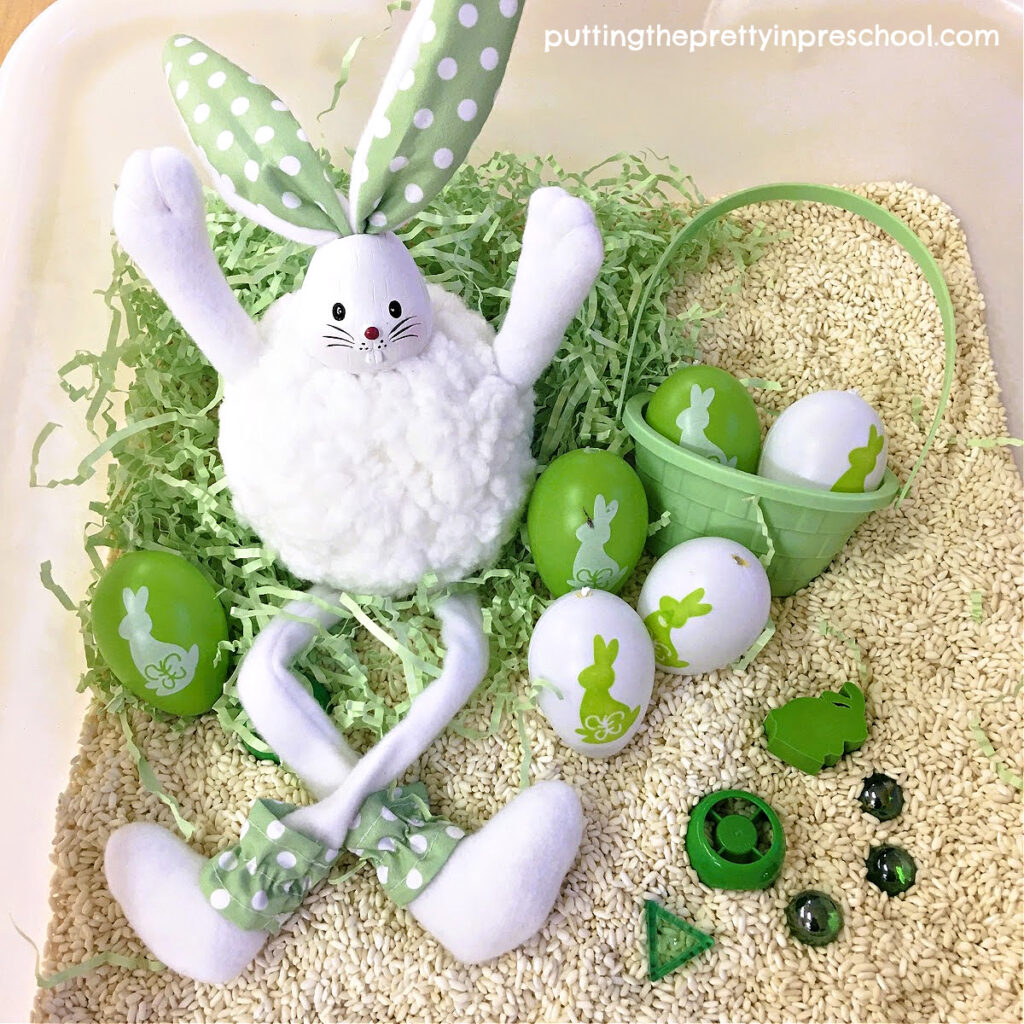 This green and white bunny-themed rice bin gives you all the feels. Loose parts coordinate with the bunnies and eggs in the bin.