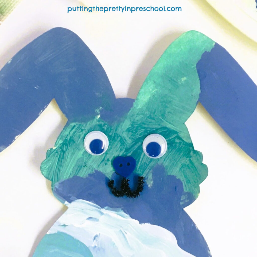 Wiggly eyes, a button nose, and a pipe cleaner mouth create a bunny face.