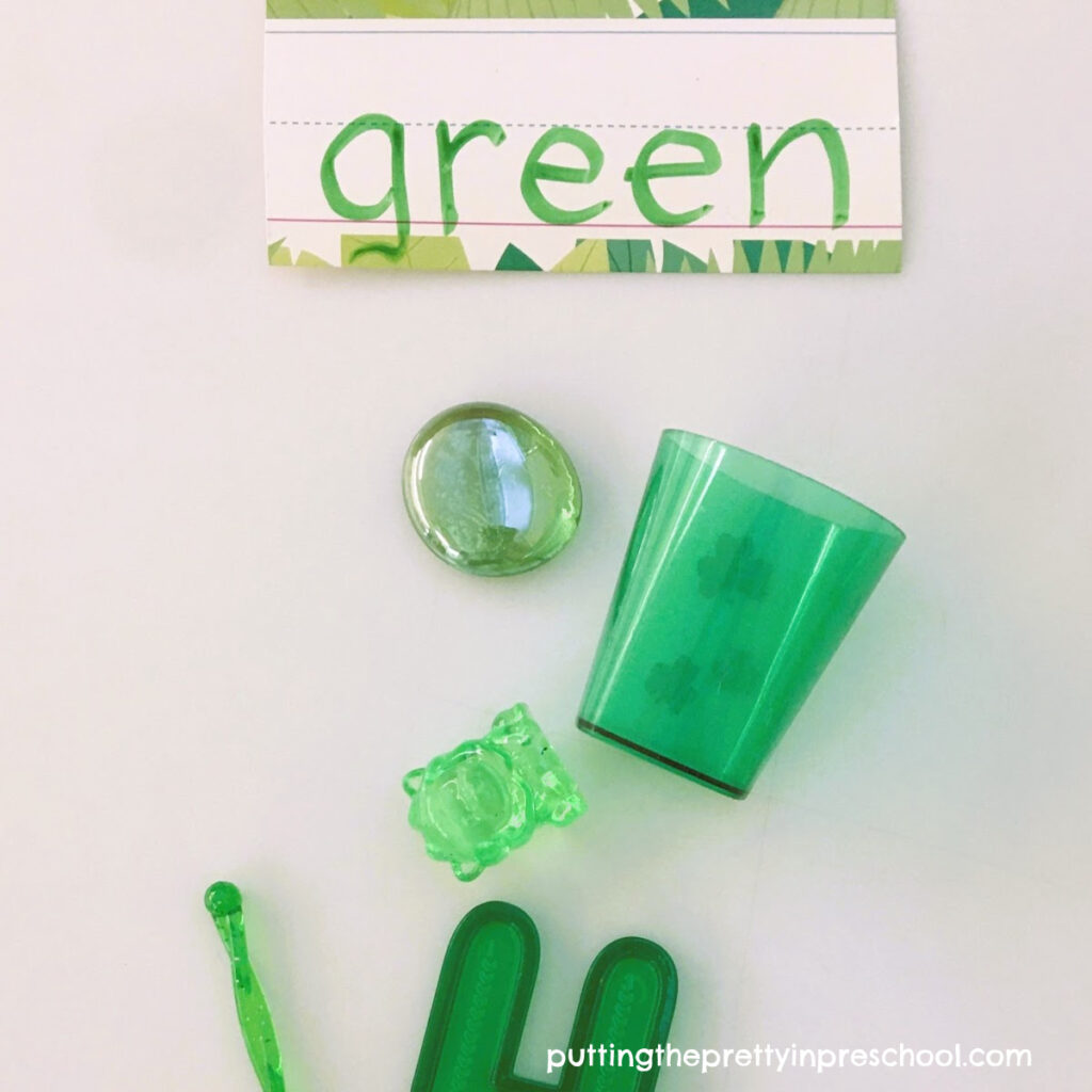 An opportunity to sort green loose parts on a St. Patrick's Day light table filled with transparent treasures to explore.