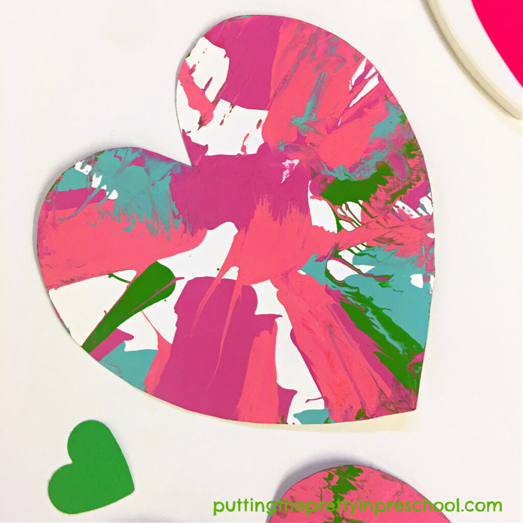 Gorgeous spin art heart created with a salad spinner and tempera paints. It's a process art activity your little learners will love.