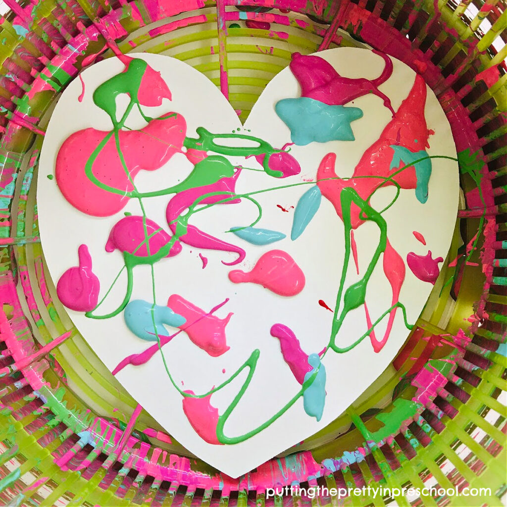 Super fun salad spinner heart art that results in unique process art projects every time. Pick your tempera paint colors and have fun spinning.