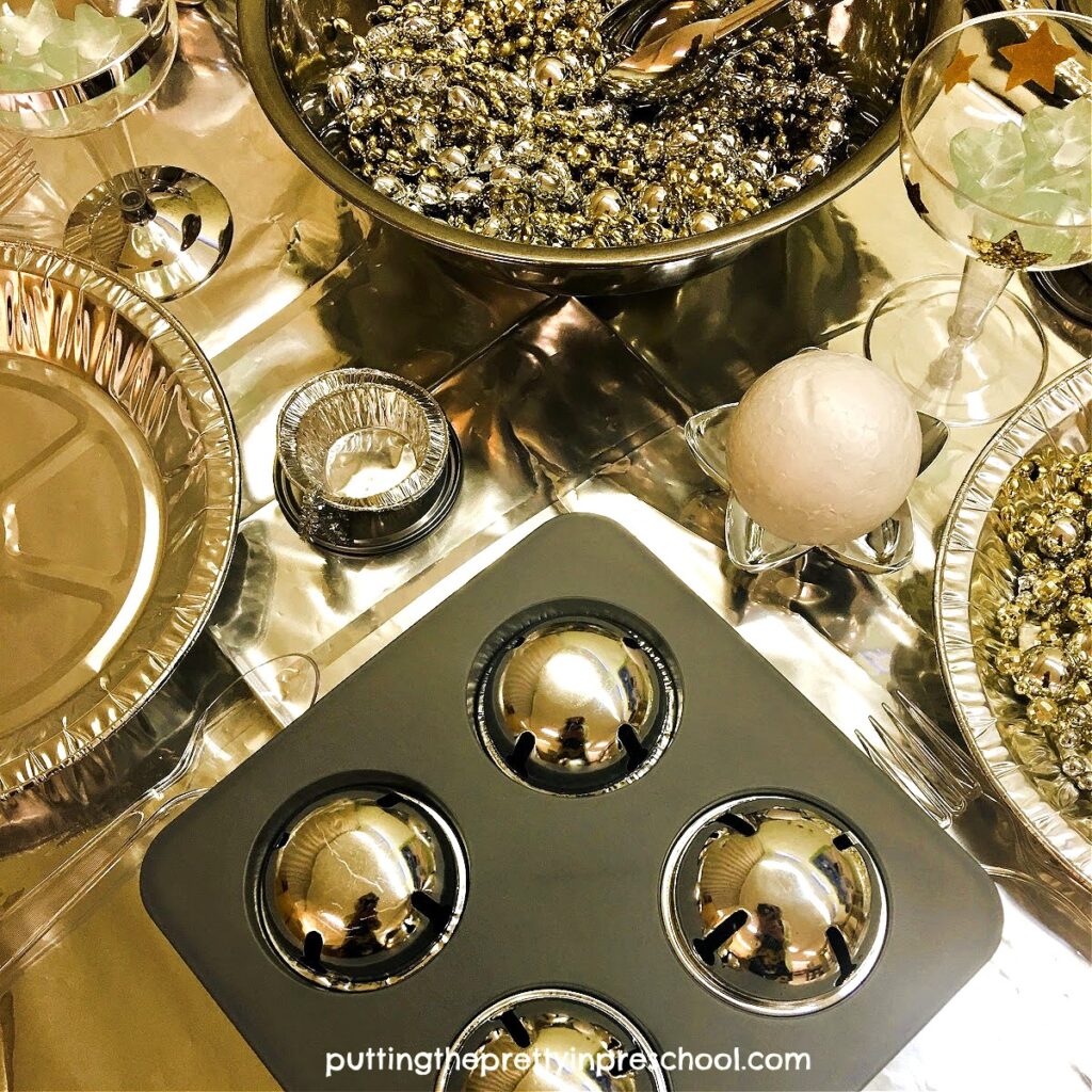 Stryfoam balls and large metallic silver bells add interest to an outer space play food table display.