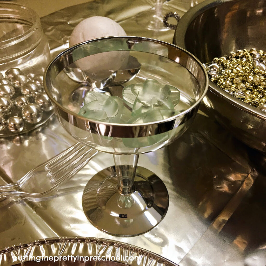 A silver-edged goblet with resusable star ice cubes co-ordinates well with a space-themed pretend play tablescape.