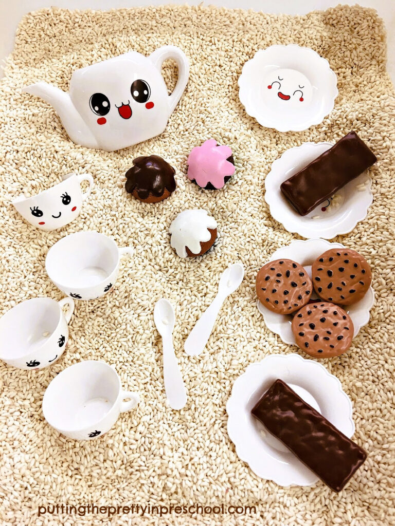 Dessert playfood and a toy tea set are inviting to play with when set in a rice-based sensory bin.