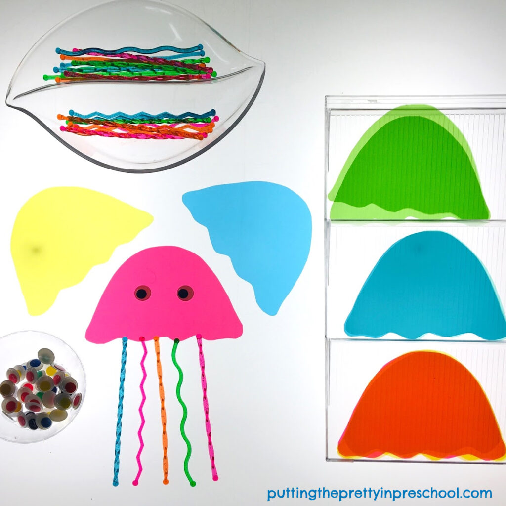 Invitation to create jellyfish on a light table with transparent stir sticks and page divider cut outs. Wiggly eyes are the finishing touch.