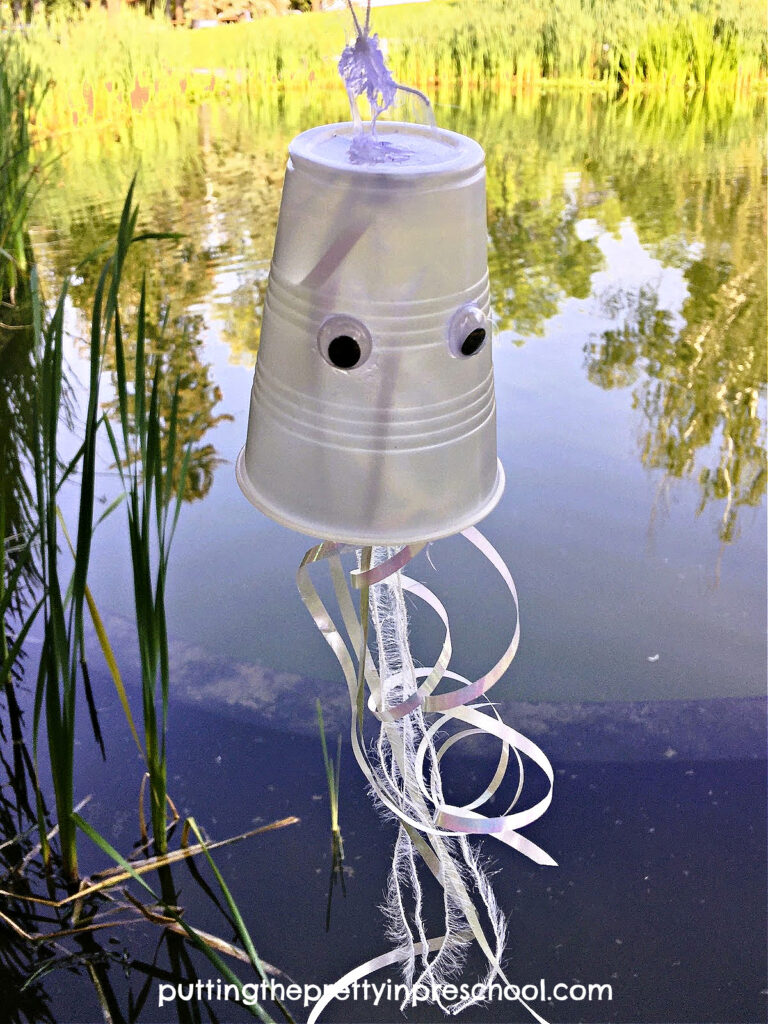 Design this cute jellyfish cup craft using iridescent supplies. Display it indoors or outdoors to add ambiance to an ocean creature theme.