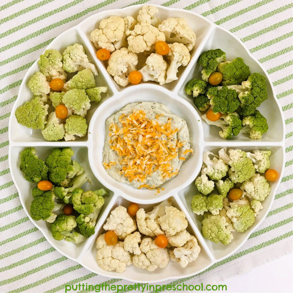 An eye-appealing vegetable tray with cream and green cauliflower and orange cherry tomatoes.