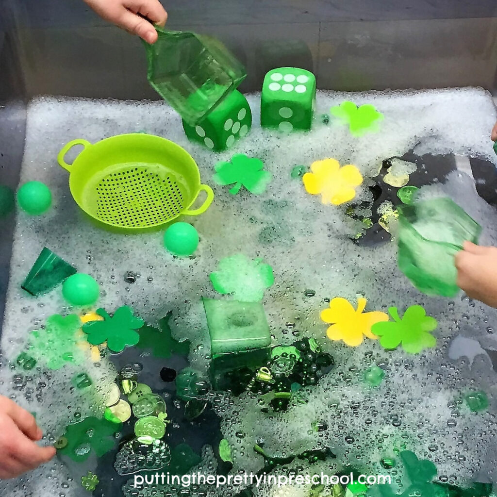 St. Patrick's day themed water table featuring green and gold items with bubbles added.