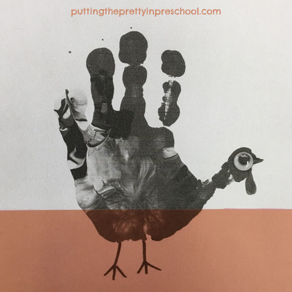 Handprint turkey enhanced with a strip of transparent page divider.