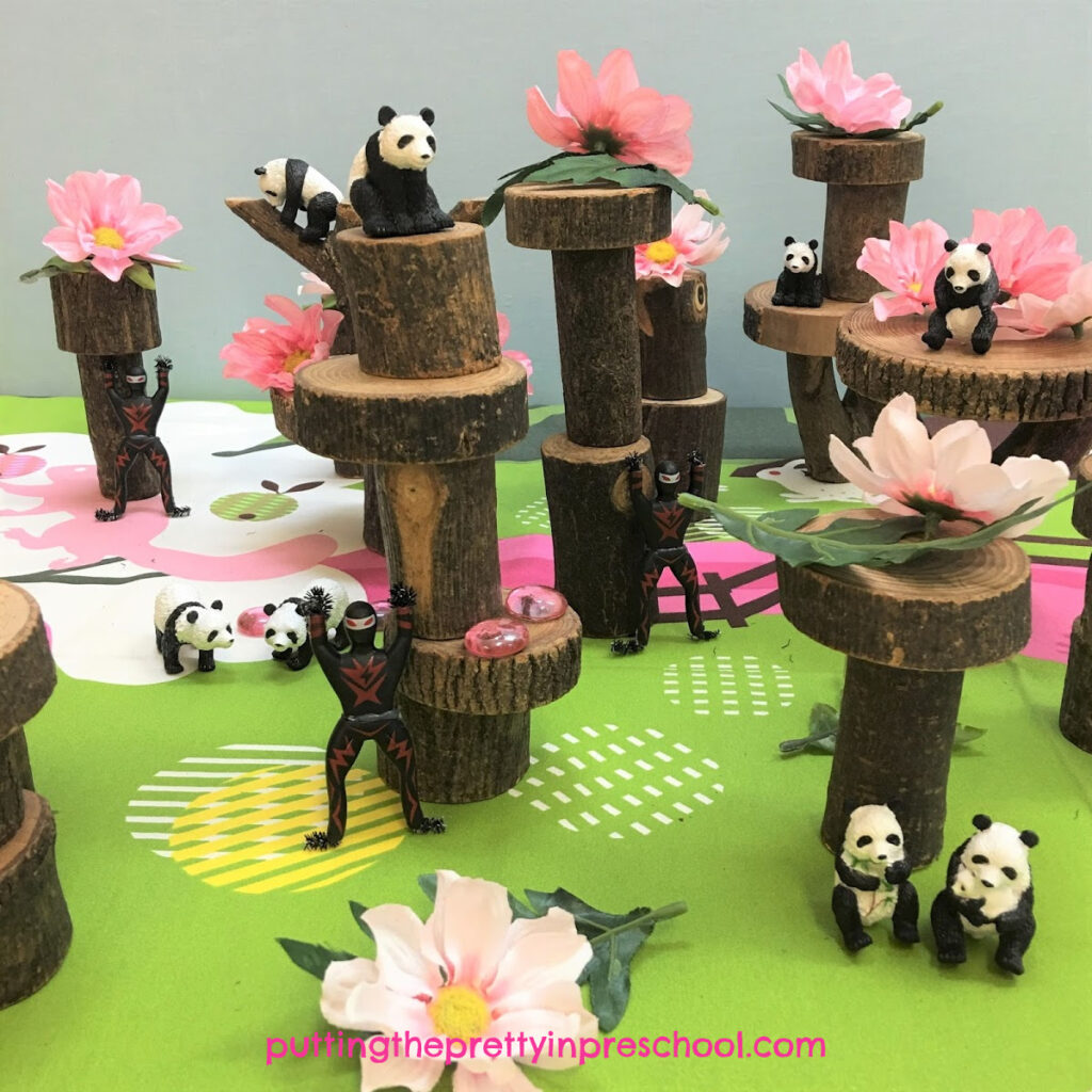 Cherry blossom tree small world with pink flowers, gems, and panda and ninja figurines.