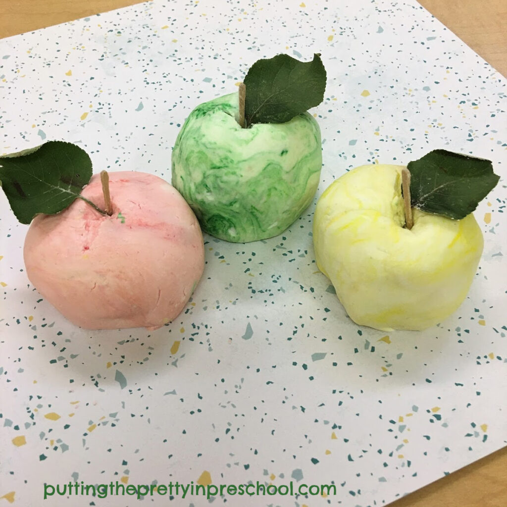 Apples created with scented, two-ingredient playdough, toothpicks, and apple leaves.