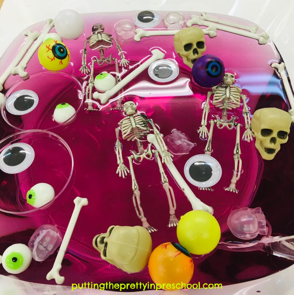 Skeleton and eyeball water play in a tulip-shaped punch bowl with eyeballs, wiggly eyes, skulls, bones, and skeletons.