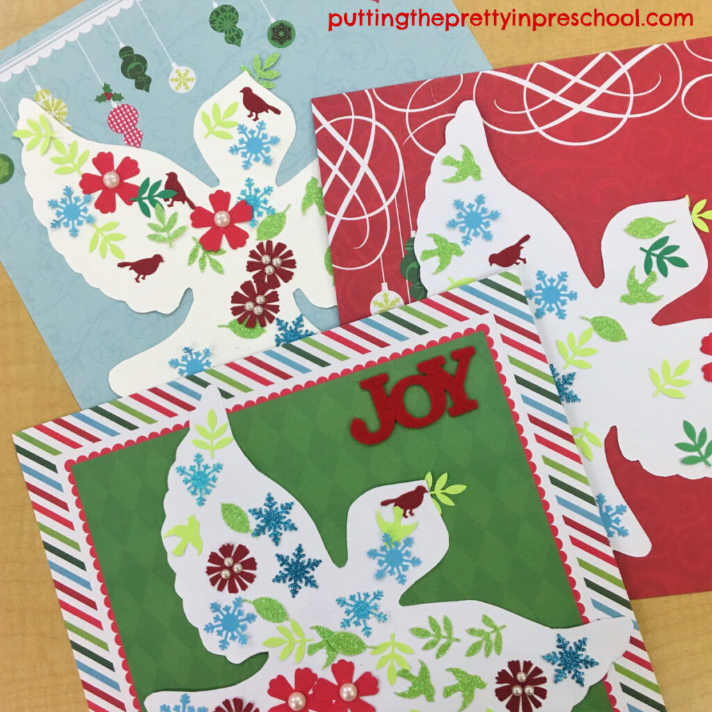 Papercraft dove collage projects mounted on Christmas-themed backgrounds.