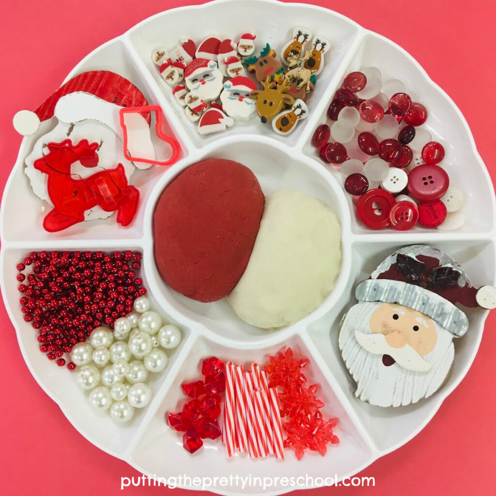 Festive red and white playdough tray with a Santa Claus theme.