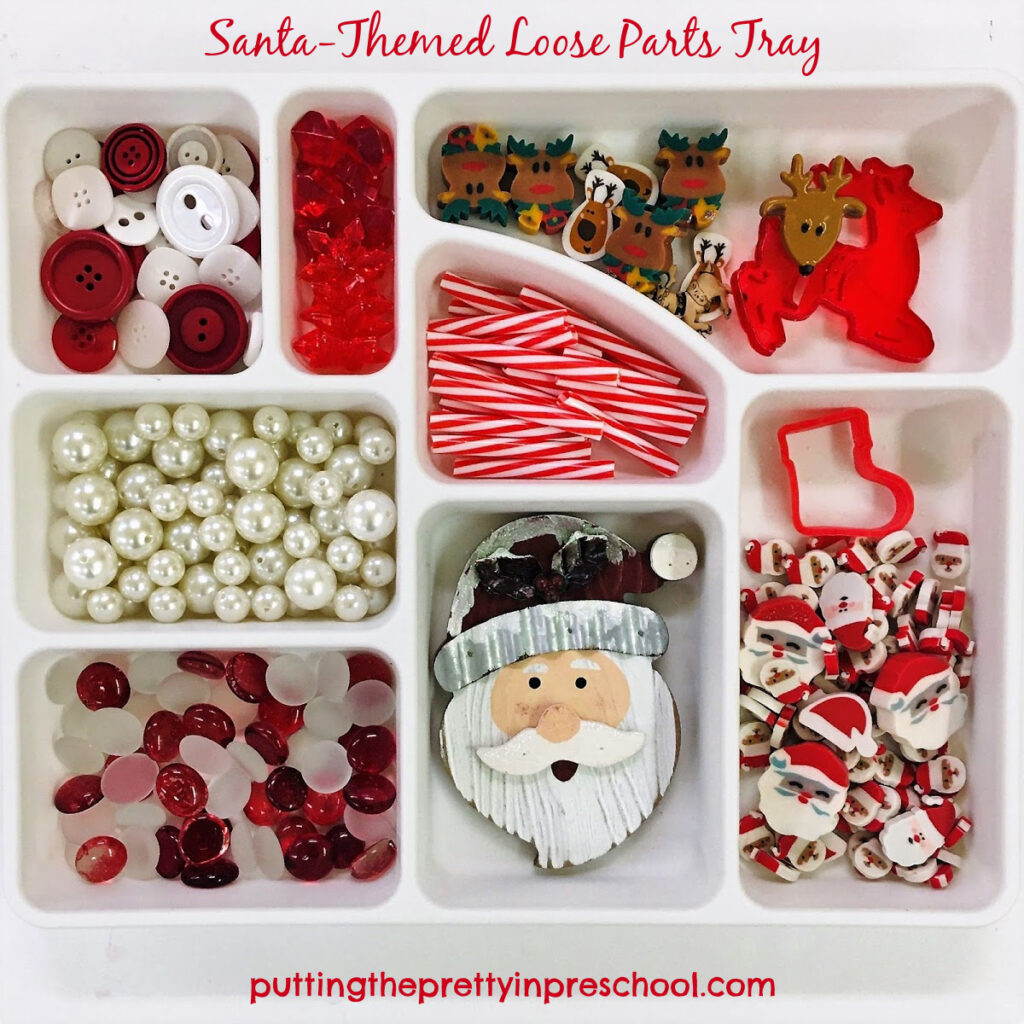 Santa Claus-themed sensory tray with red and white loose parts.