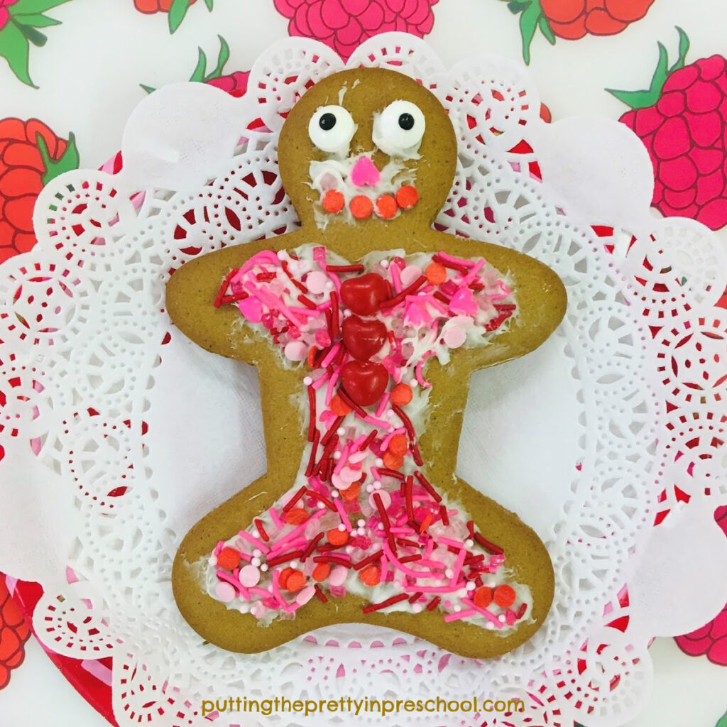 A gingerbread cookie decorated with hearts and candy sprinkles.