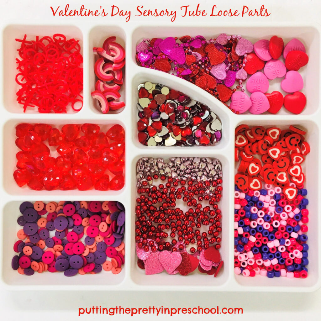 Valentine's day loose parts tray with pieces for sensory tubes.