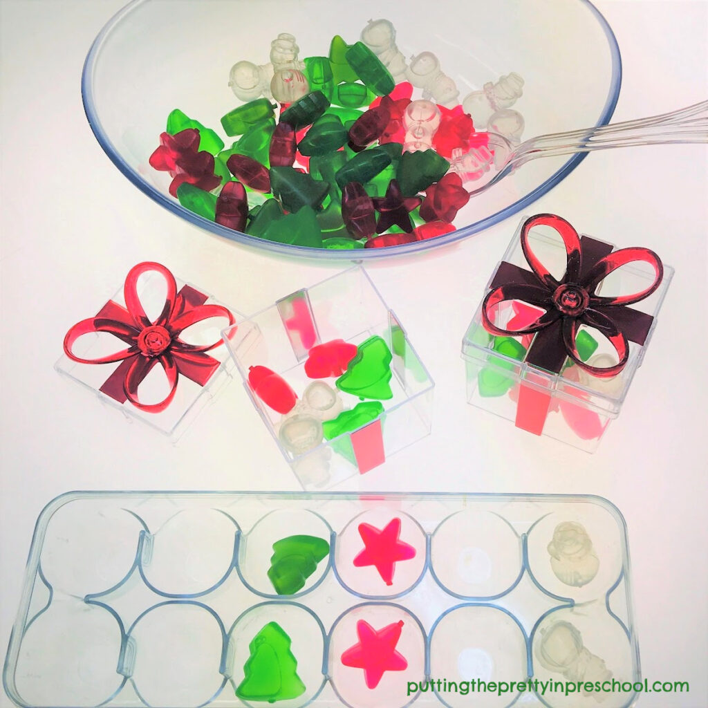 Counting, sorting, and scooping opportunities at the light table with Christmas-themed reusable ice cubes and clear containers.