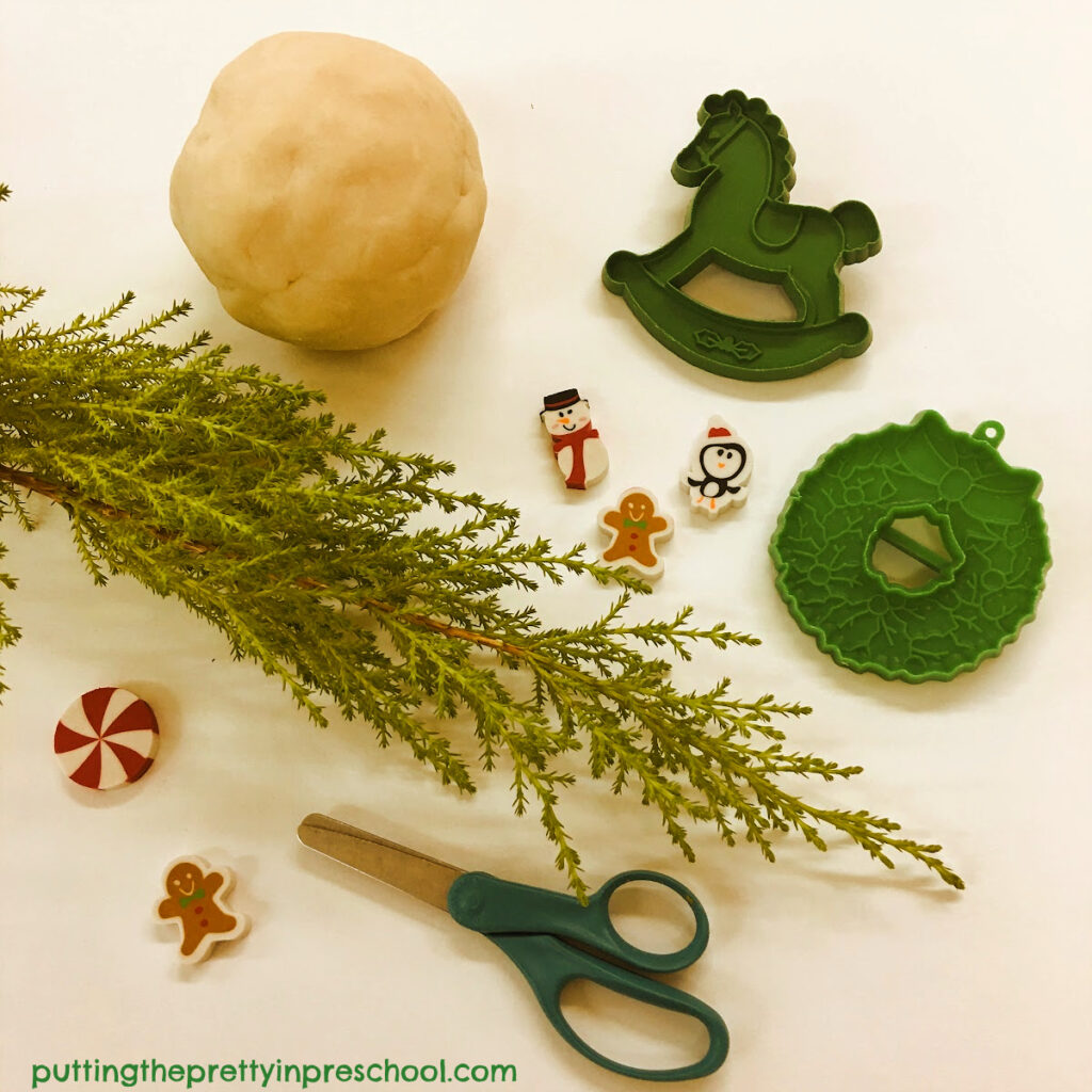 Offer lemon cypress sprigs with scissors, cookie cutters, and erasers in a fragrant Christmas playdough activity.
