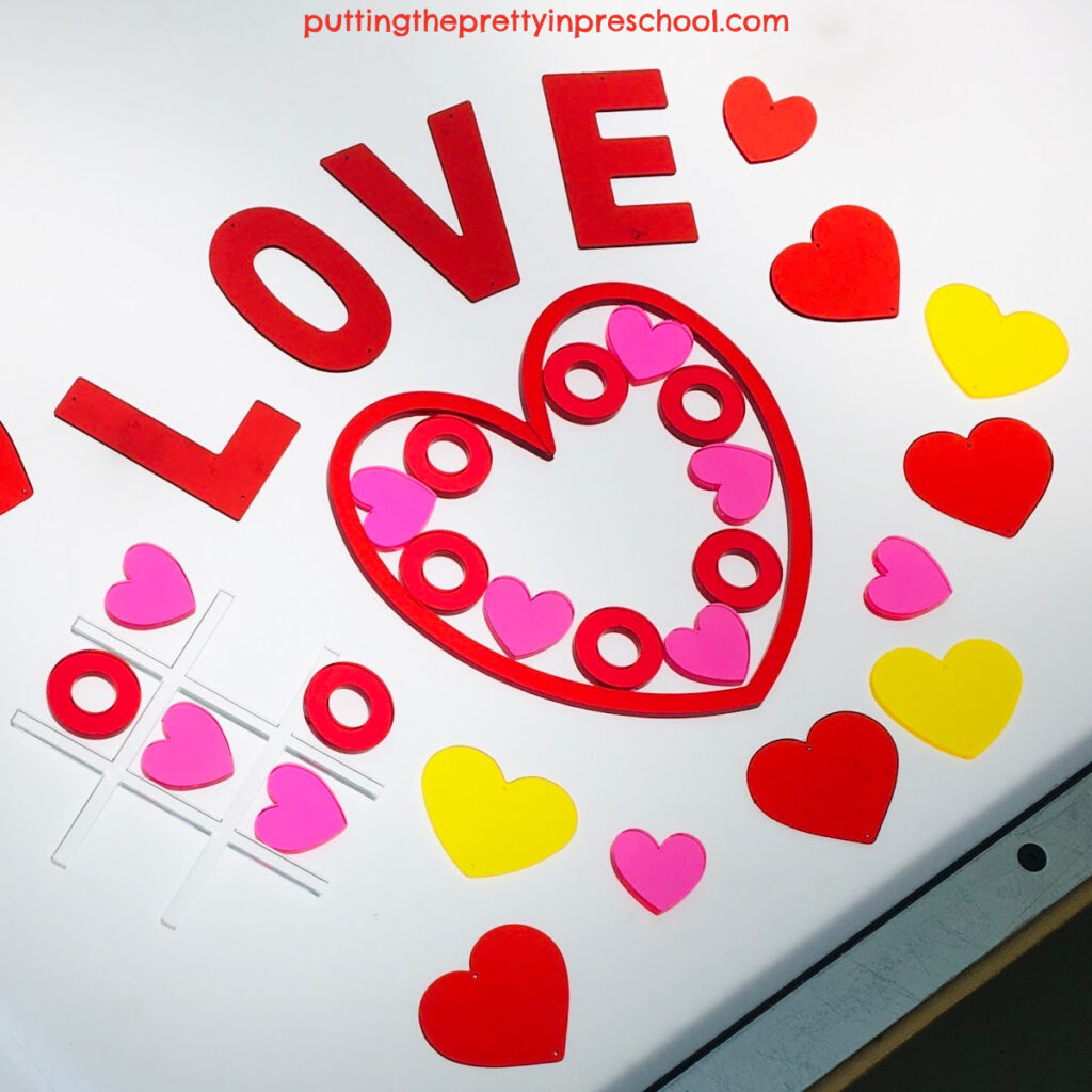 A Valentine's Day light table activity with transparent loose parts to use for math, games, and transient art.