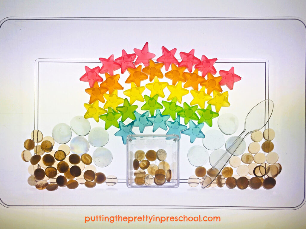 Transparent gems and star-shaped reusable ice cubes are the highlights of this rainbow sensory tray.