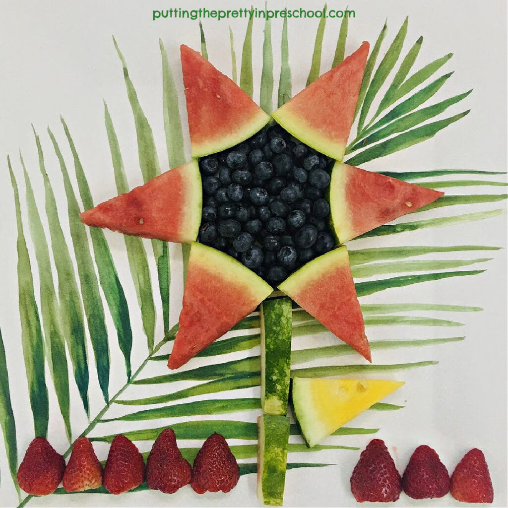 Create a juicy sunflower with red watermelon petals, a yellow watermelon leaf, and a blueberry seed center.
