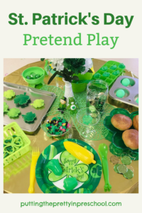 A green and gold St. Patrick's Day pretend play tablescape filled with themed play kitchen accessories to explore.